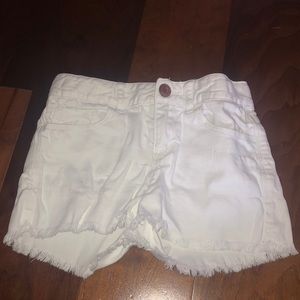 White kids short shorts with distressed bottoms.